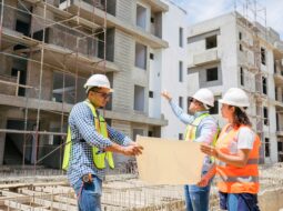 Construction professionals reviewing building plans at a commercial development site during a construction project.
