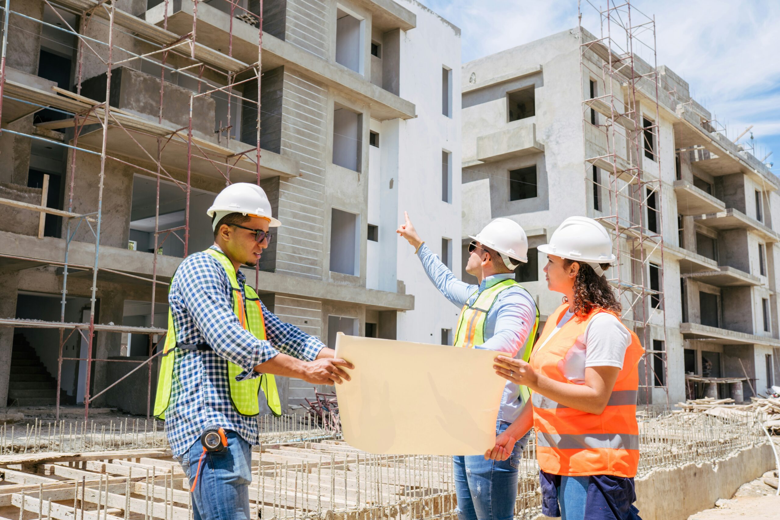 Construction professionals reviewing building plans at a commercial development site during a construction project.